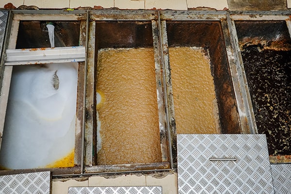 during grease trap maintenance, the trap is pumped, cleaned, and inspected for any issues or damage